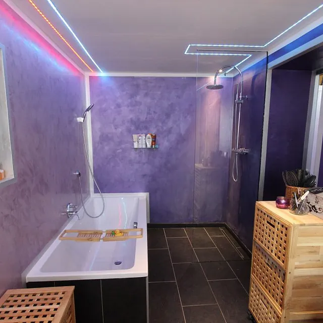  Stilvolles Badezimmer in lila Tönen, ausgestattet mit einer gemütlichen Badewanne für entspannende Momente.