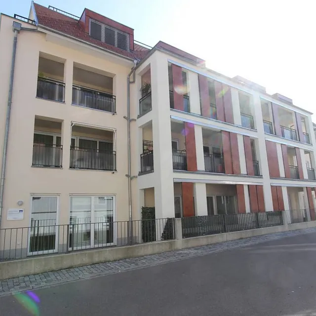 Ein Gebäude mit Balkonen und Fenstern an der Seite, das eine moderne Architektur ausstrahlt.