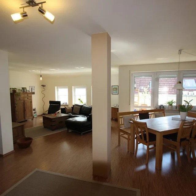 Helles Wohnzimmer, ausgestattet mit einem eleganten Esstisch und bequemen Stühlen für entspannte Essenszeiten.
