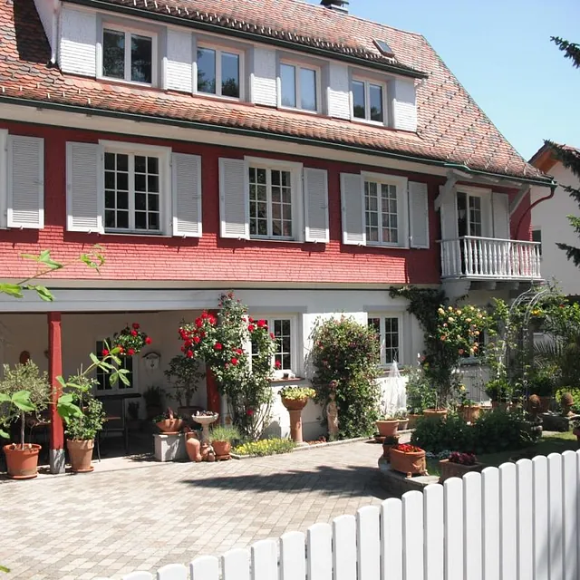 Ein imposantes Haus in Rot und Weiß, das sich harmonisch in die Landschaft einfügt und zum Verweilen einlädt.