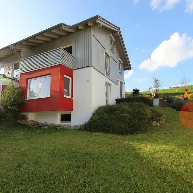 Ein Haus mit roter und weißer Fassade, das einladend und charmant wirkt.